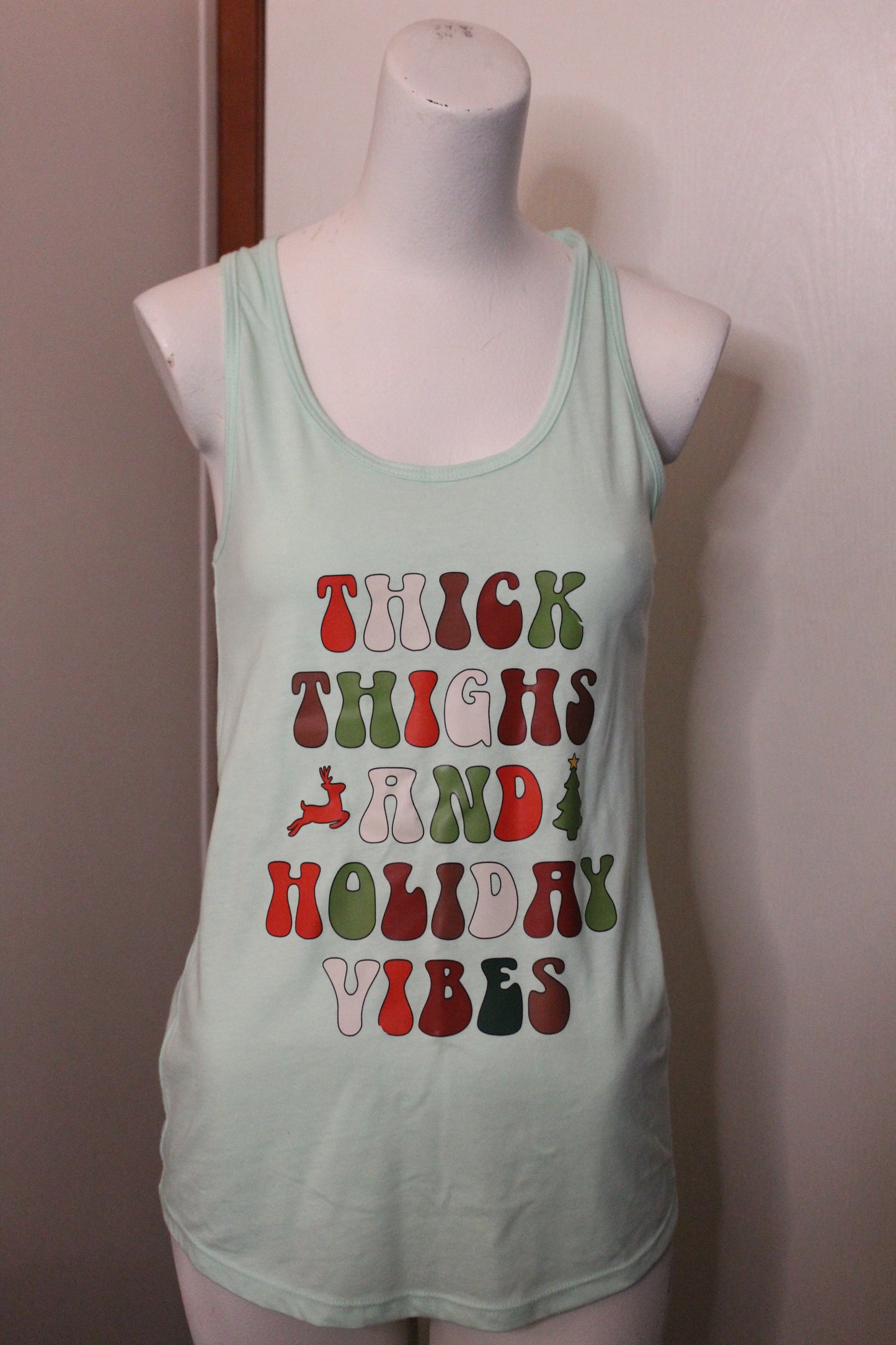 Tank top with colorful text design on a mannequin against a plain background